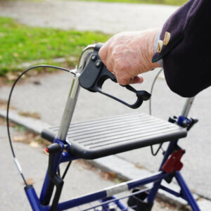 Senior geht mit Rollator duch Park